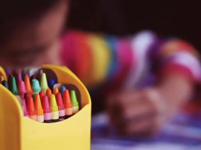 A child coloring with crayons.