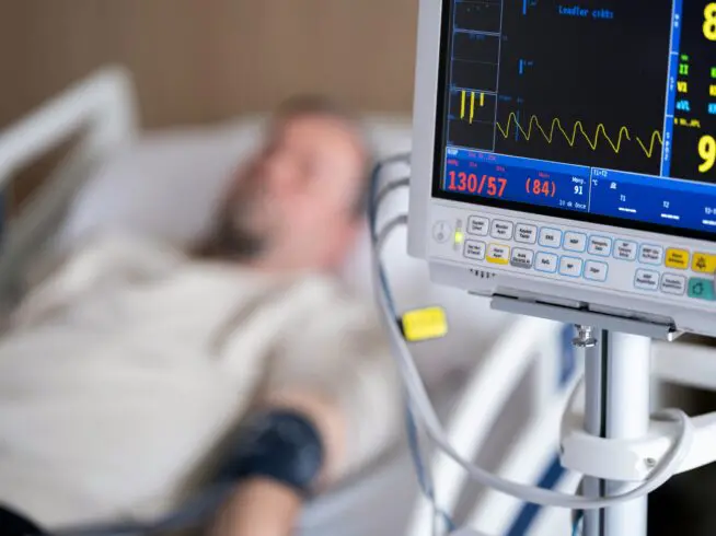 Person laying in a hospital bed.