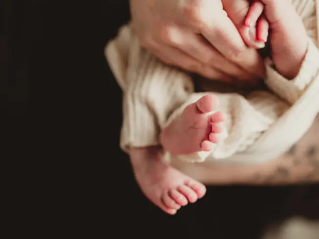 Parent holding a newborn baby.